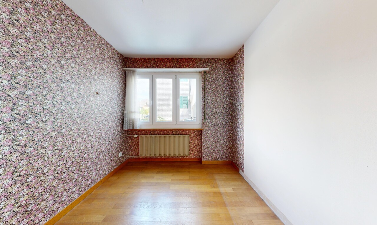 spare room with wallpapered walls, light wood-style floors, and radiator heating unit