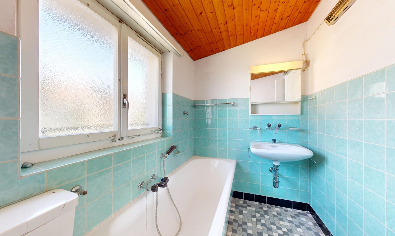 full bath featuring a bath, tile walls, a vaulted wood ceiling, and wainscoting