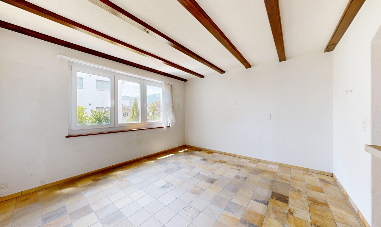 empty room featuring beam ceiling and baseboards