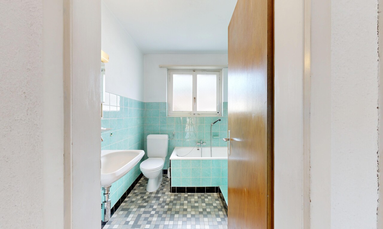 bathroom featuring tile walls, a bath, and a wainscoted wall