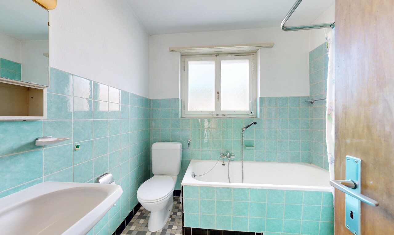 bathroom featuring tile walls, a wainscoted wall, and tiled shower / bath combo