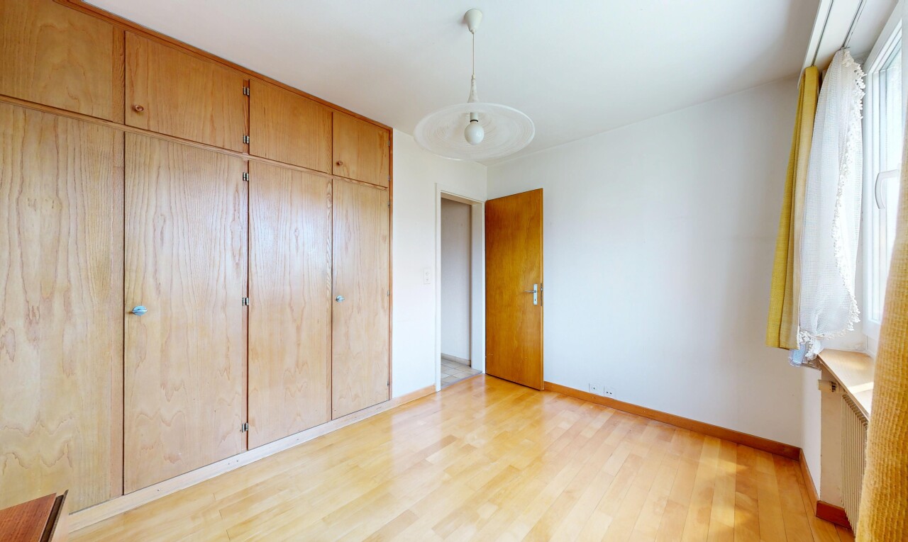 unfurnished room featuring a closet, light wood-type flooring, and hanging light fixtures
