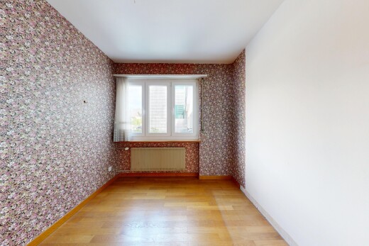 spare room with wallpapered walls, light wood-style floors, and radiator heating unit