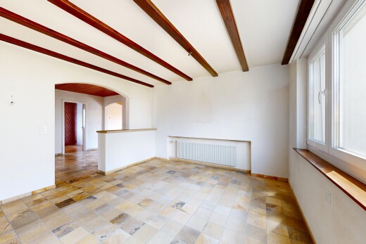spare room featuring beamed ceiling, radiator heating unit, and arched walkways