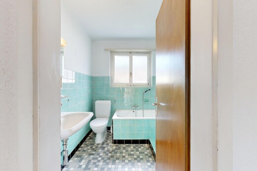 bathroom featuring tile walls, a bath, and a wainscoted wall
