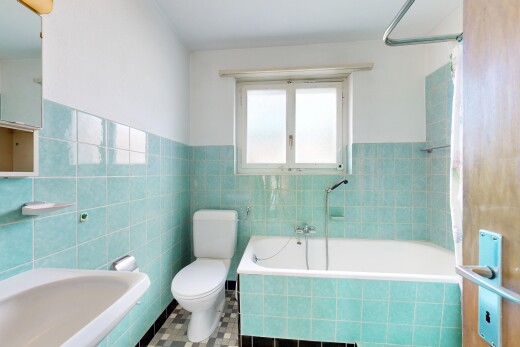 bathroom featuring tile walls, a wainscoted wall, and tiled shower / bath combo