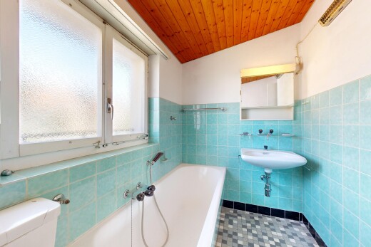full bath featuring a bath, tile walls, a vaulted wood ceiling, and wainscoting