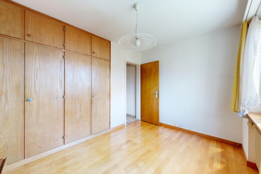 unfurnished room featuring a closet, light wood-type flooring, and hanging light fixtures