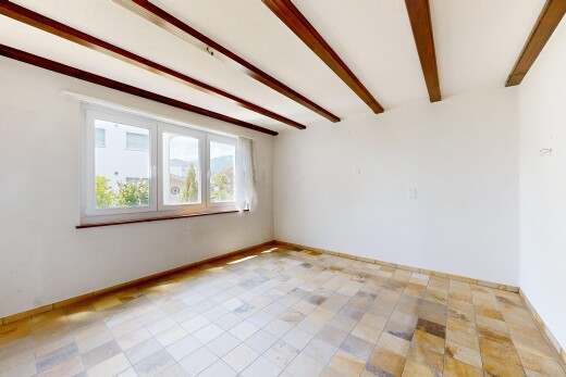 empty room featuring beam ceiling and baseboards