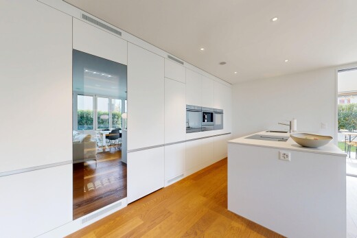 cuisine avec armoires à panneau plat, sol en finition bois, wood finish floor, lumière naturelle, et natural light