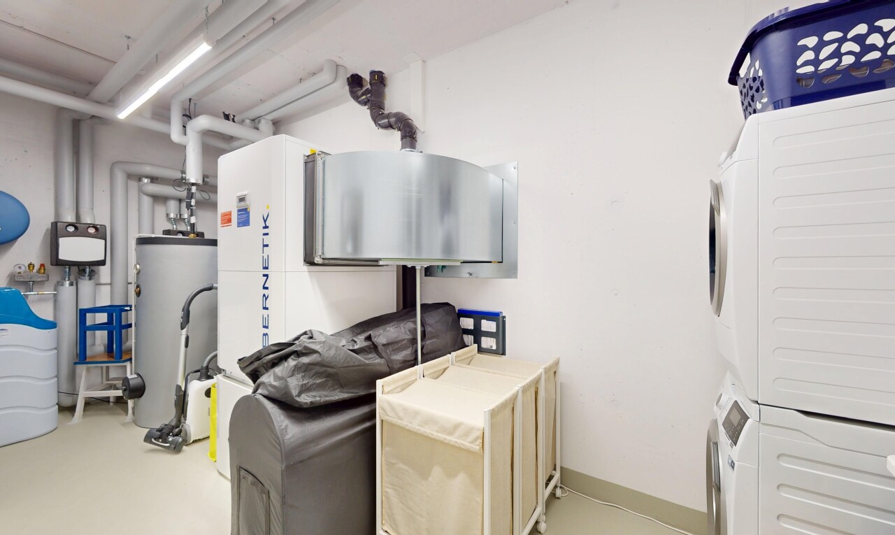 buanderie avec inside property, chauffe-eau, lave-linge et sèche-linge superposés, drywall, et cloison sèche