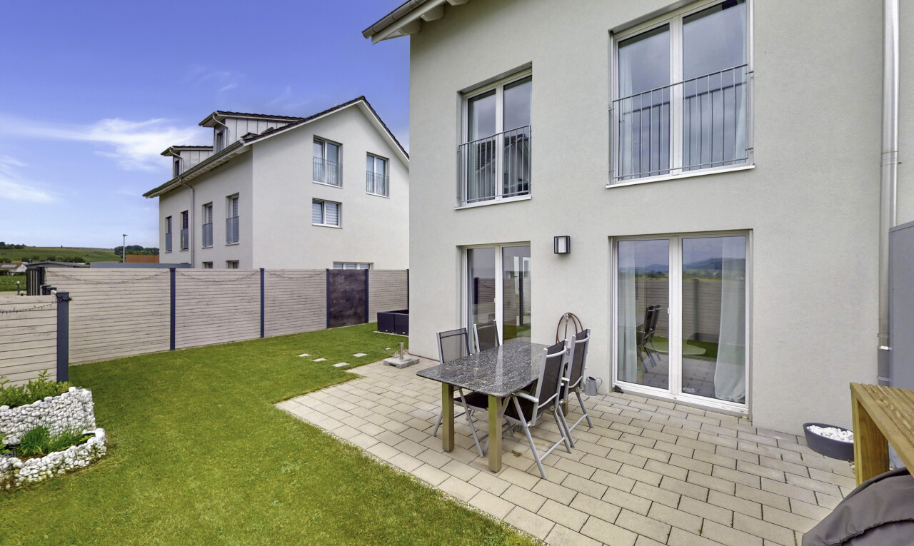 façade avec pelouse, clôture, terrasse, bardage en stuc, et property visible