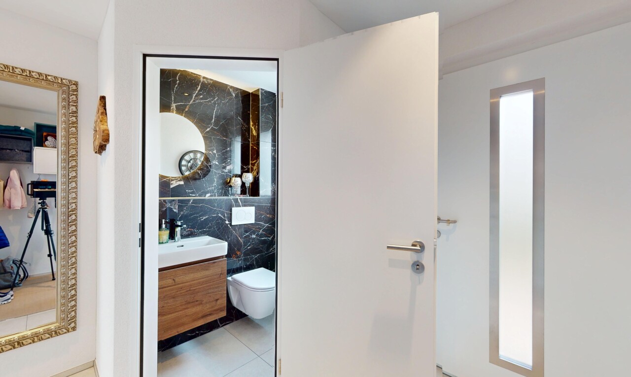 salle de bains avec miroir, lavabo (ou coiffeuse selon le contexte), toilette, inside property, et mur en carrelage