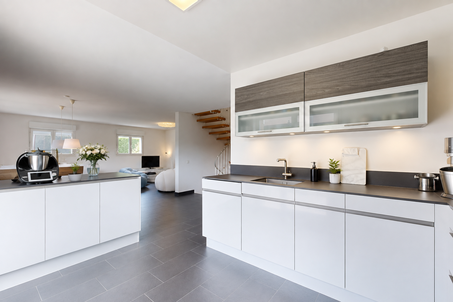 cuisine avec dark countertops, plans de travail, escaliers, évier, et drywall