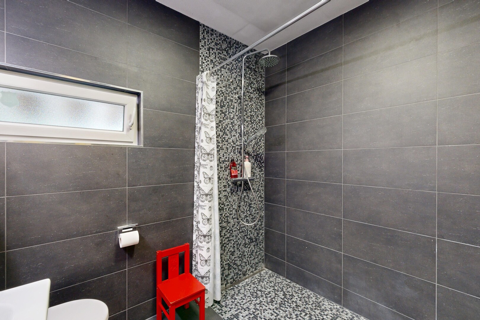 salle de bains avec tile wall, mur en carrelage, douche, salle de bain complète, et lumière naturelle