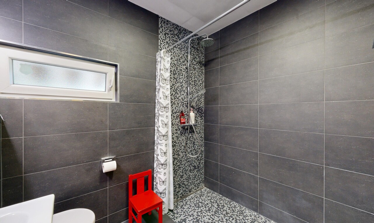 salle de bains avec tile wall, mur en carrelage, douche, salle de bain complète, et lumière naturelle