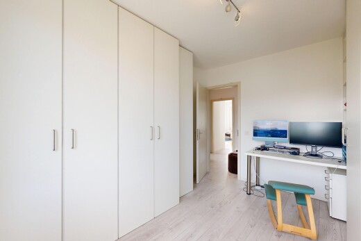bureau avec wood finish floor, sol en finition bois, éclairage sur rail, télévision, et light floor