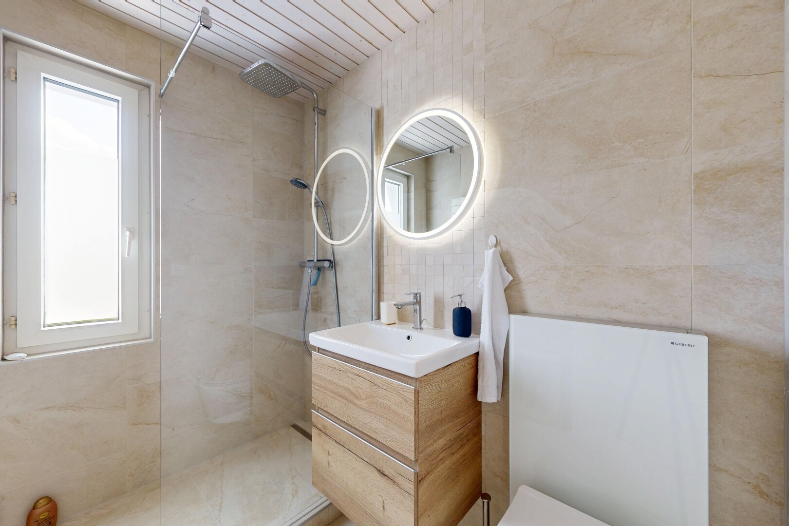 salle de bains avec lavabo (ou coiffeuse selon le contexte), miroir, douche, salle de bain complète, et tile wall