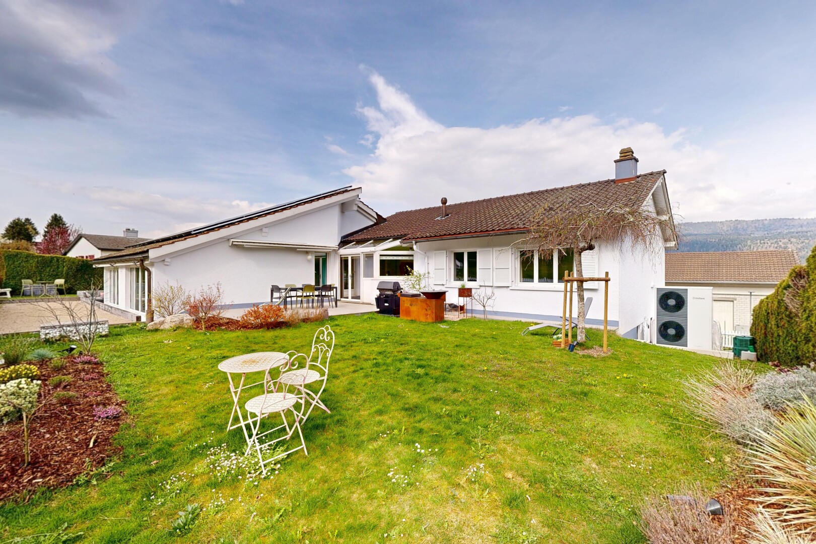 façade avec property visible, day time, bardage en stuc, pelouse, et terrasse