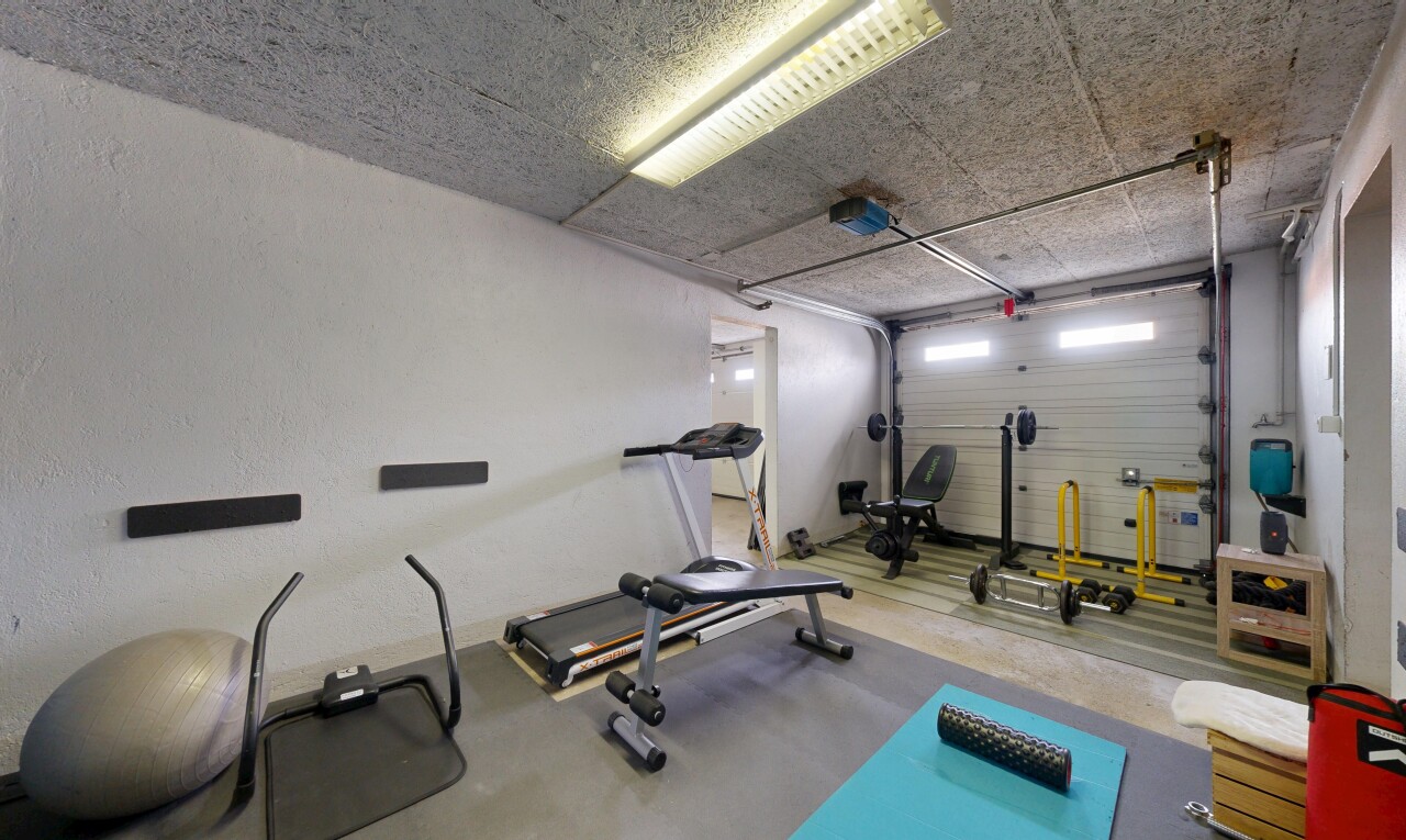 gym avec inside property, garage, sol en béton, concrete floor, et cloison sèche