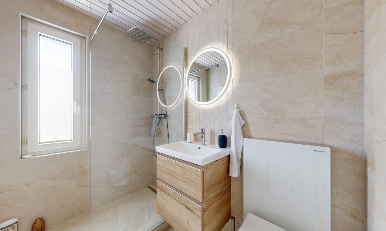 salle de bains avec lavabo (ou coiffeuse selon le contexte), miroir, douche, salle de bain complète, et tile wall