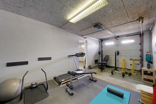 gym avec inside property, garage, sol en béton, concrete floor, et cloison sèche