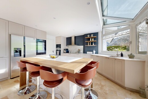 kitchen featuring wood counters, open shelves, stainless steel fridge with ice dispenser, a center island, and a breakfast bar