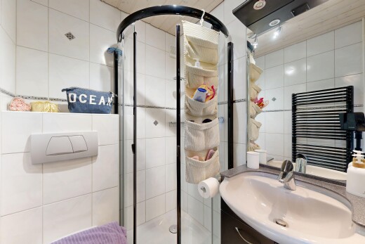 salle de bains avec miroir, salle de bain complète, radiateur, douche, et mur en carrelage