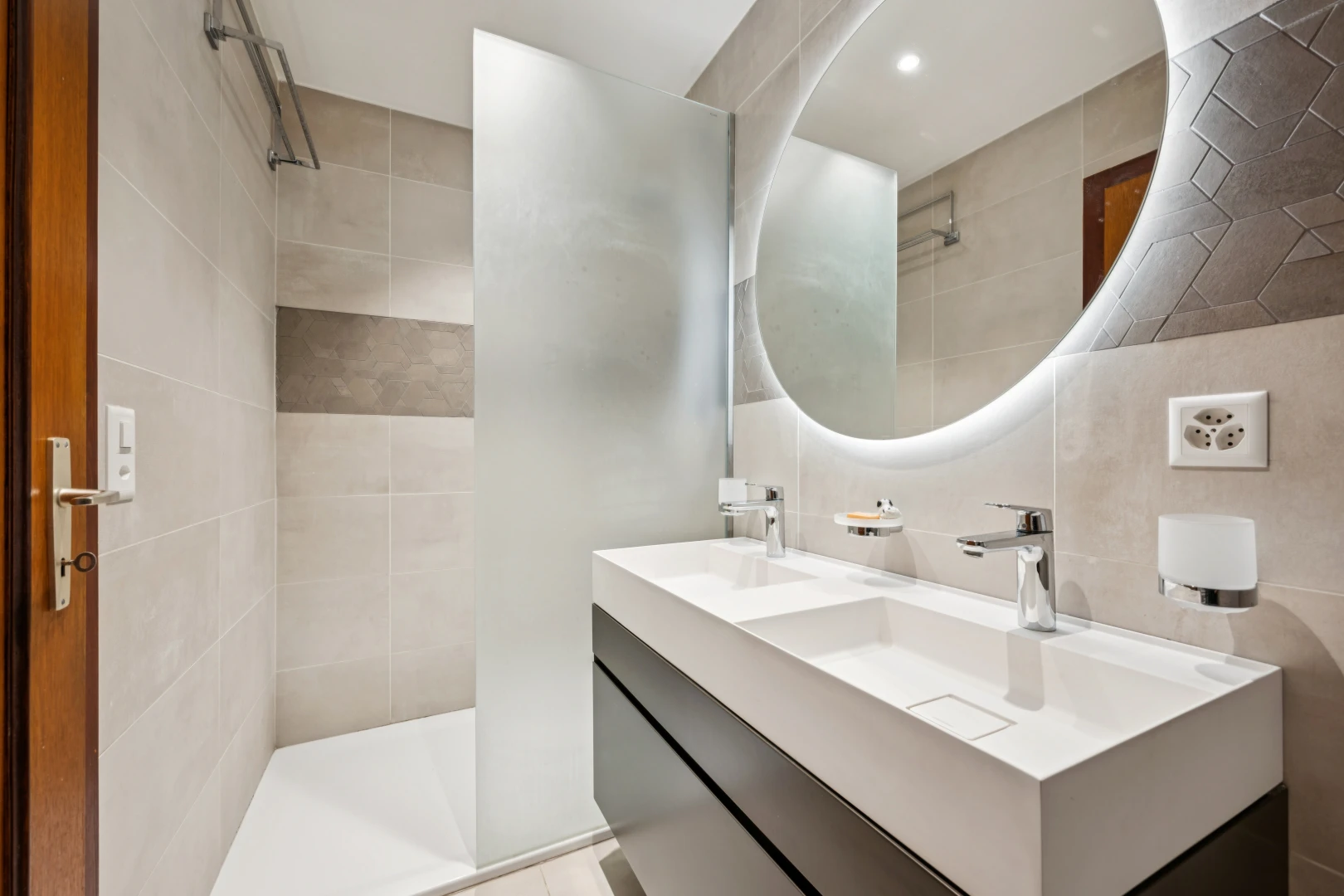 salle de bains avec salle de bain complète, miroir, douche, double vasque, et éclairage encastré