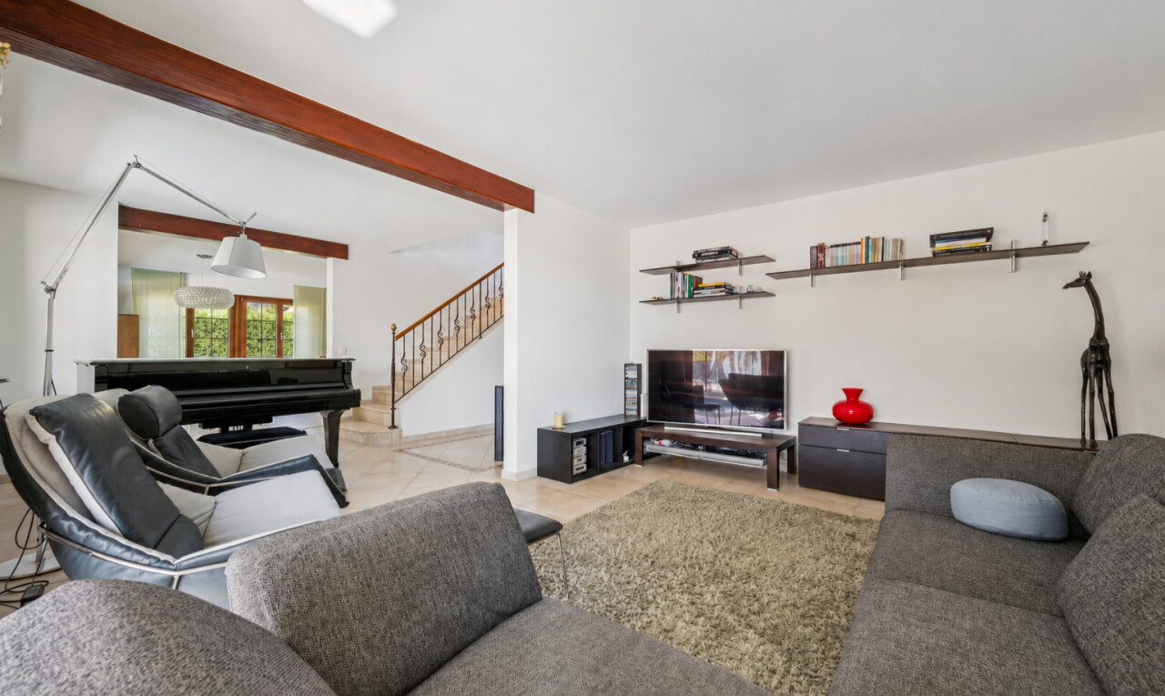 wohnzimmer mit treppen, gipskartonwand, drywall, fernseher, und high end ceiling