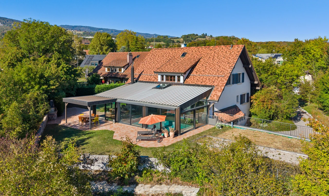 façade avec terrasse, drone view, clôture, toit en métal, et property visible