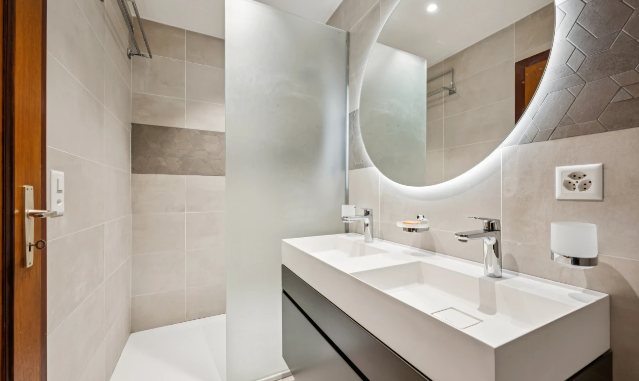 salle de bains avec salle de bain complète, miroir, douche, double vasque, et éclairage encastré