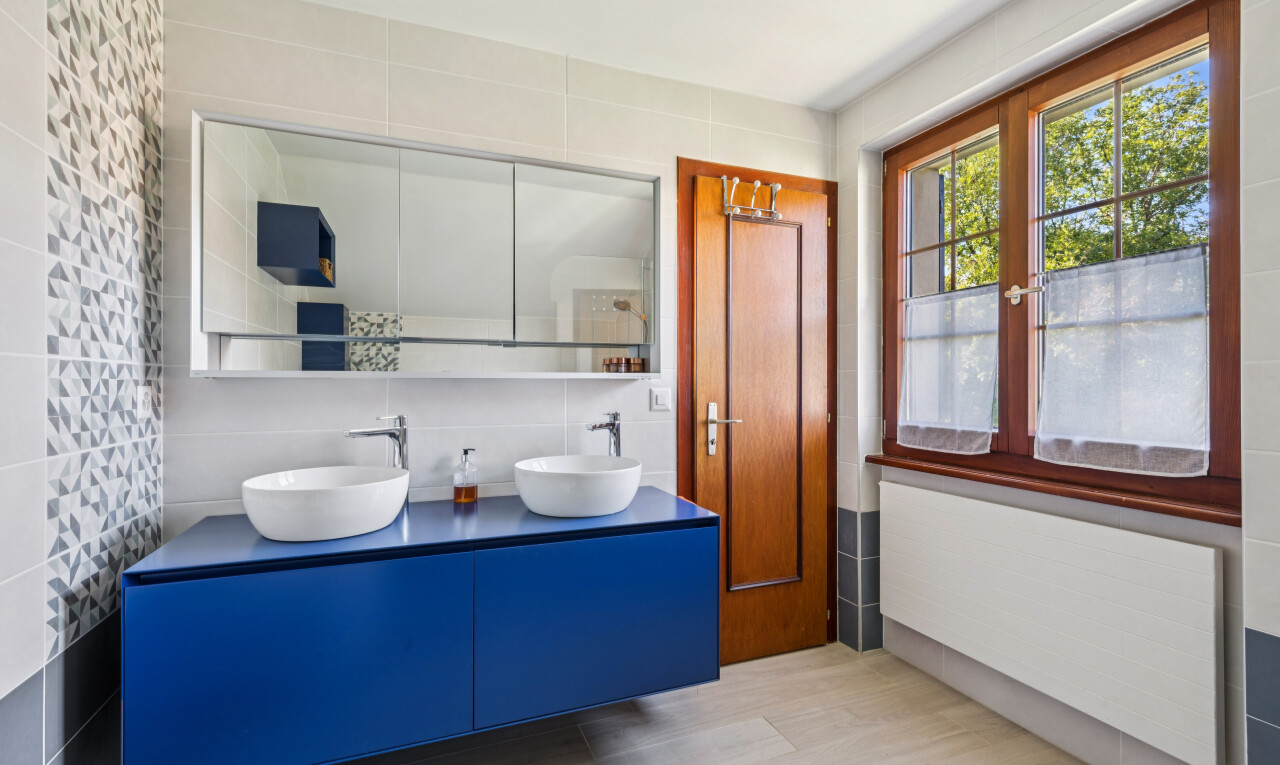 salle de bains avec mur en carrelage, tile wall, radiateur, double vasque, et évier