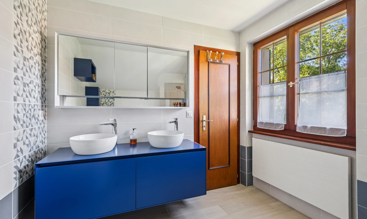 salle de bains avec mur en carrelage, tile wall, radiateur, double vasque, et évier
