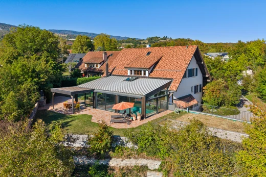 façade avec terrasse, drone view, clôture, toit en métal, et property visible