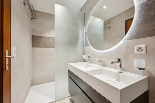 salle de bains avec salle de bain complète, miroir, douche, double vasque, et éclairage encastré