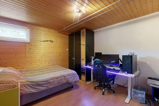 chambre avec espace bureau, sol en finition bois, wood finish floor, mur en bois, et wood wall
