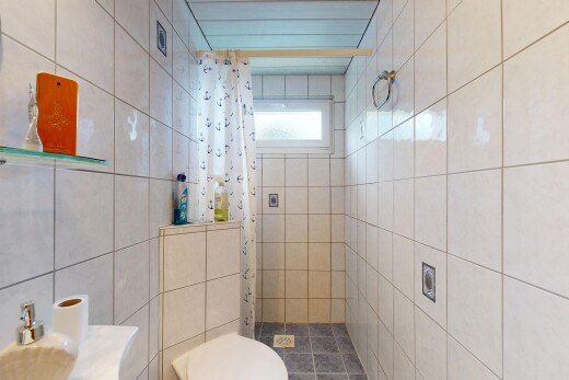 salle de bains avec douche, salle de bain complète, toilette, mur en carrelage, et tile wall