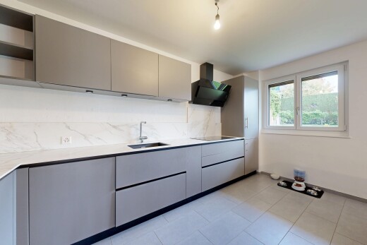 cuisine avec armoires grises, lumière naturelle, natural light, hotte, et cloison sèche