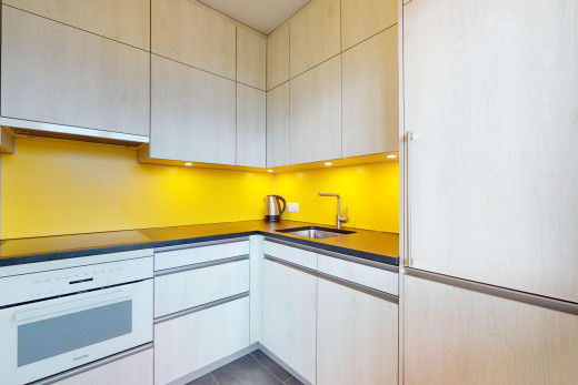 küche mit arbeitsplatten, ofen, fliesenboden, weiße schränke, und waschbecken