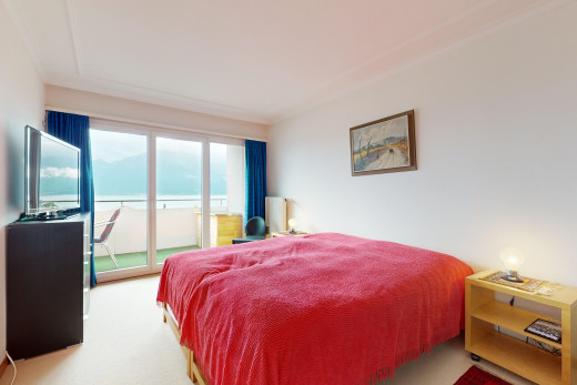 zimmer / schlafzimmer mit teppich, außenzugang, fernsehen, wasserblick, und natürliches licht