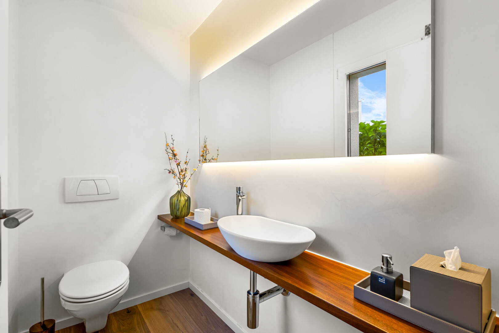 salle de bains avec évier, miroir, toilette, sol en finition bois, et wood finish floor