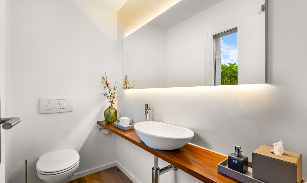 bad mit waschbecken, spiegel, toilette, holzfußboden, und wood finish floor