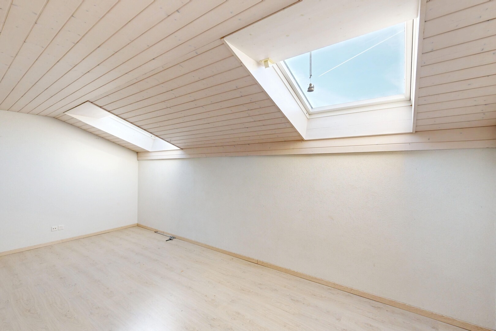pièce vide avec cloison sèche, drywall, sol en finition bois, wood finish floor, et puits de lumière