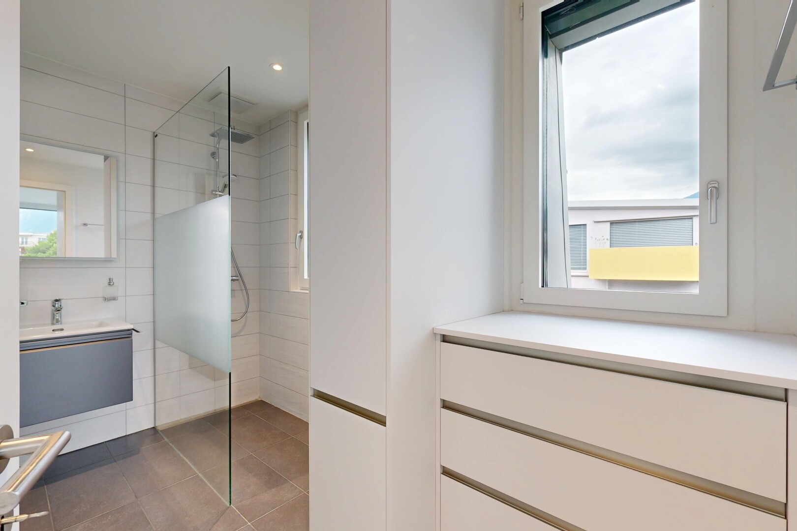 salle de bains avec lumière naturelle, natural light, miroir, salle de bain complète, et lavabo (ou coiffeuse selon le contexte)