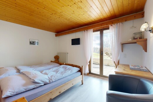 zimmer / schlafzimmer mit holzdecke, fernseher, gipskartonwand, natürliches licht, und außenzugang