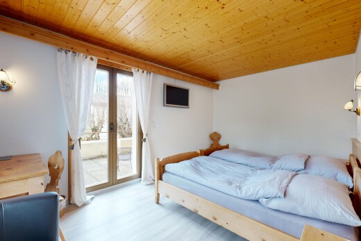 zimmer / schlafzimmer mit holzdecke, französische türen, gipskartonwand, natürliches licht, und außenzugang