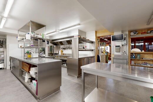 küche mit edelstahl-arbeitsplatten, offene regale, fernseher, und fliesenboden