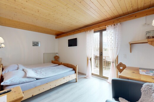 zimmer / schlafzimmer mit gipskartonwand, holzdecke, fernseher, natürliches licht, und außenzugang