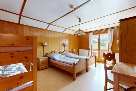 zimmer / schlafzimmer mit natürliches licht, holzfußboden, und holzwand